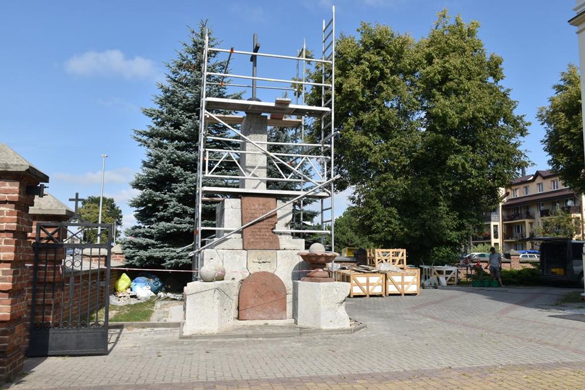 Zdjęcie przedstawia prace renowacyjne zabytkowego pomnika nagrobnego inż. Macieja Bayera przy kościele w Fajsławicach