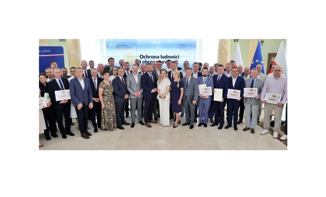 Zdjęcie przedstawia uczestników spotknia, podczas ktorego podpisano umowy na zadania z zakresu Ochrony Ludności i obrony Cywilnej, które odbyło się 29 czerwca 2026r. w sali kolumnowej Lubelskiego Urzędu Wojewódzkiego